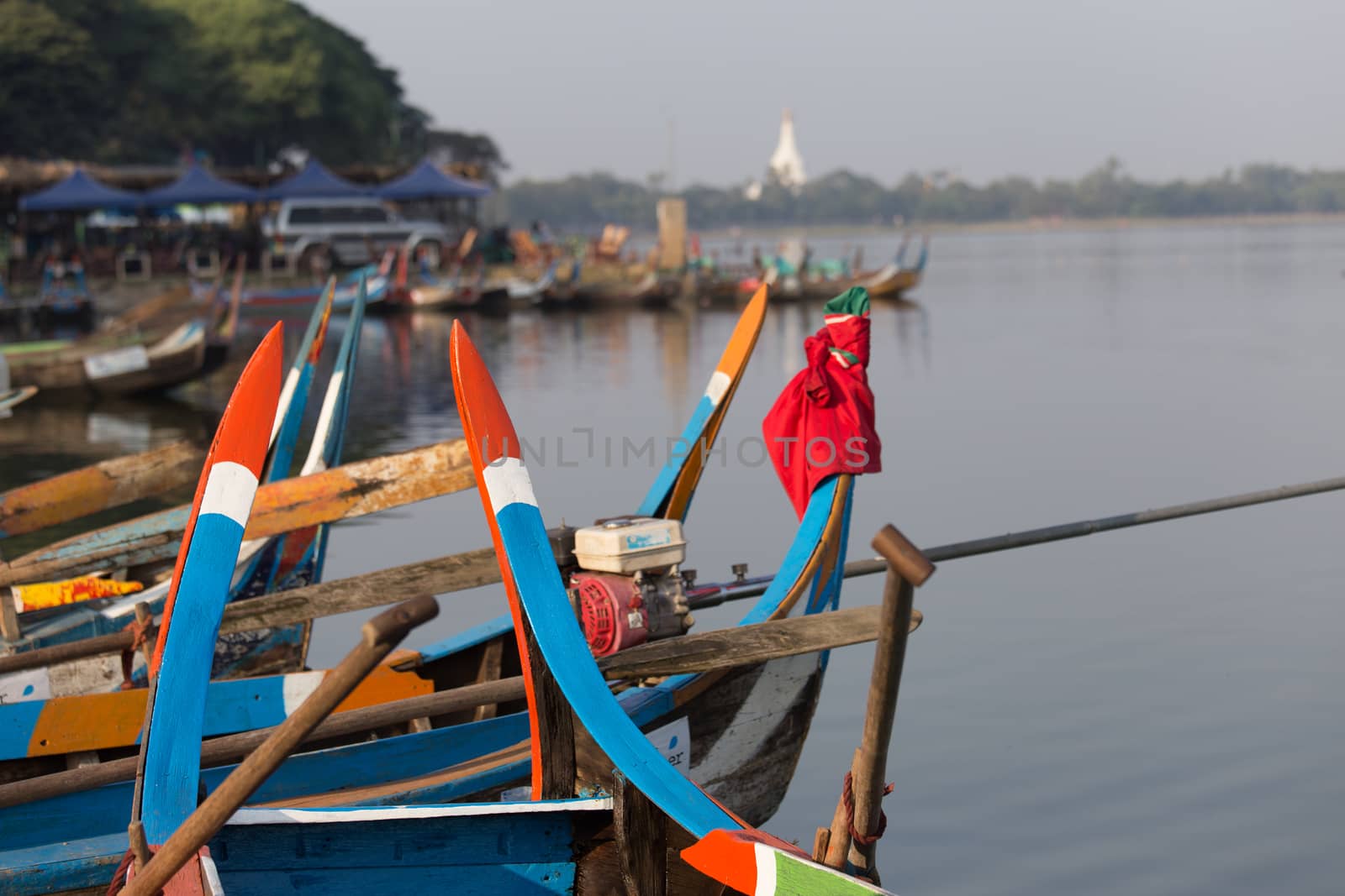 Boats moored at Taungthaman Lake near Amarapura in Myanmar by the U Bein Bridge  by kgboxford