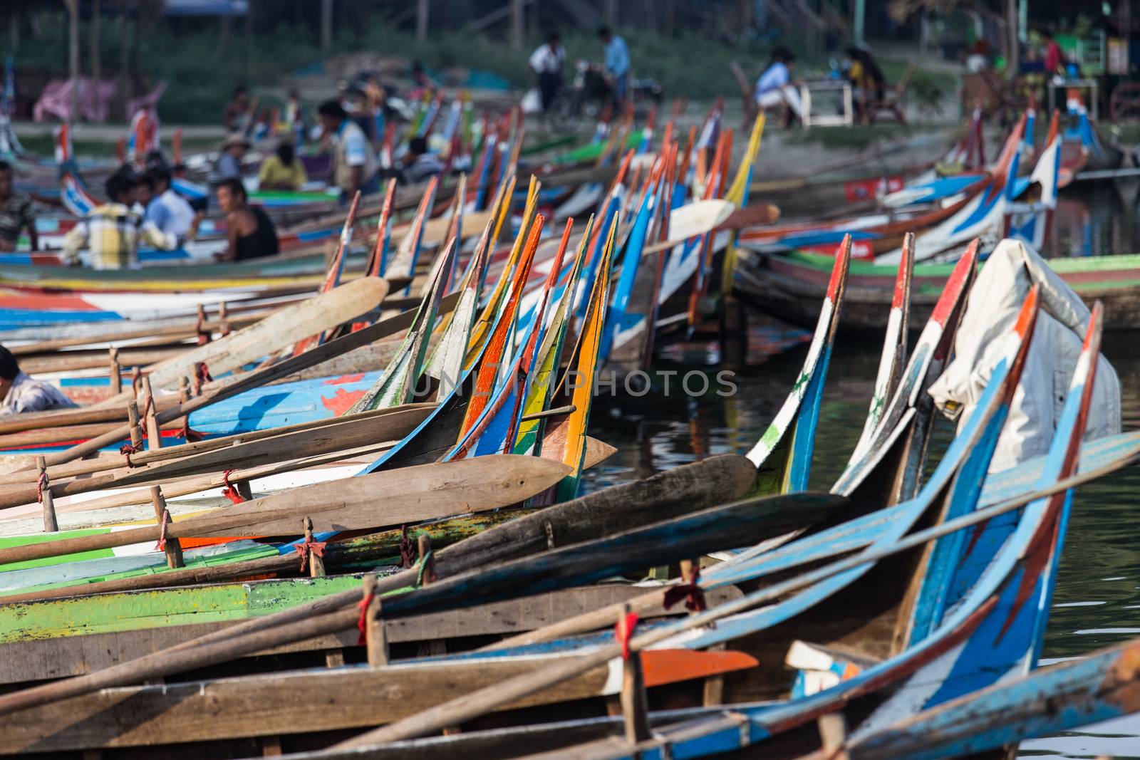 Boats moored at Taungthaman Lake near Amarapura in Myanmar by the U Bein Bridge  by kgboxford