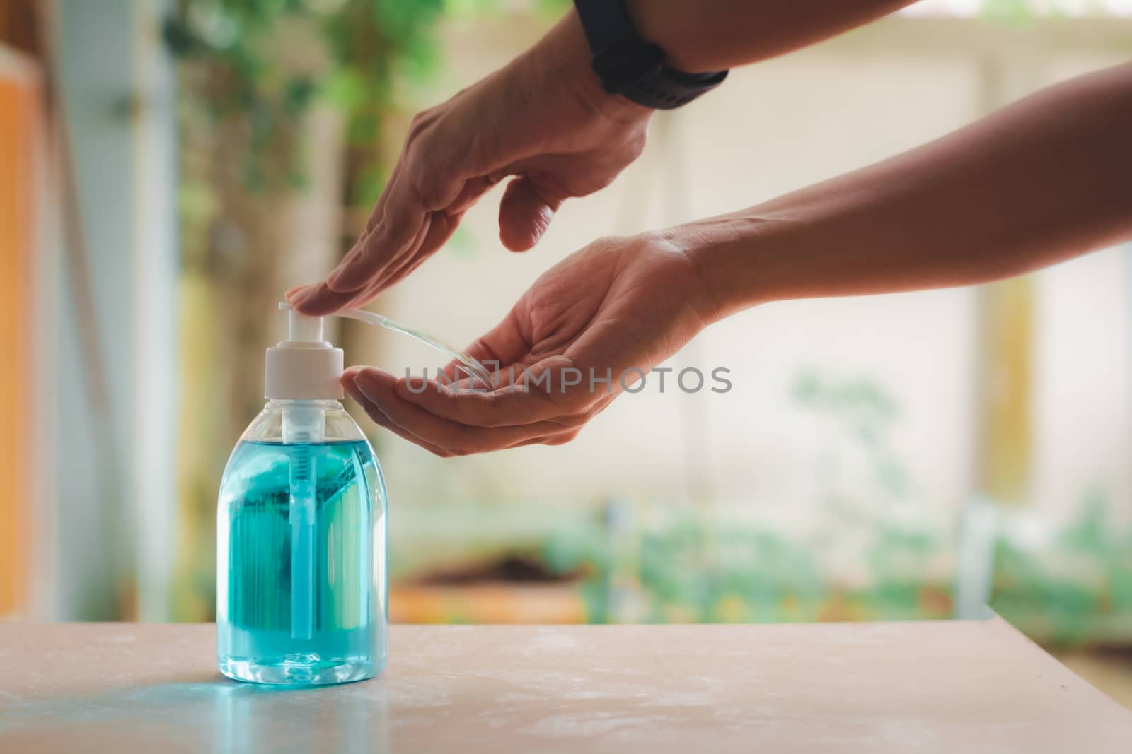 Hygiene and health care concept. Human hand pressing on a bottle of alcohol to hand for cleaning and wash protect viruses, etc.