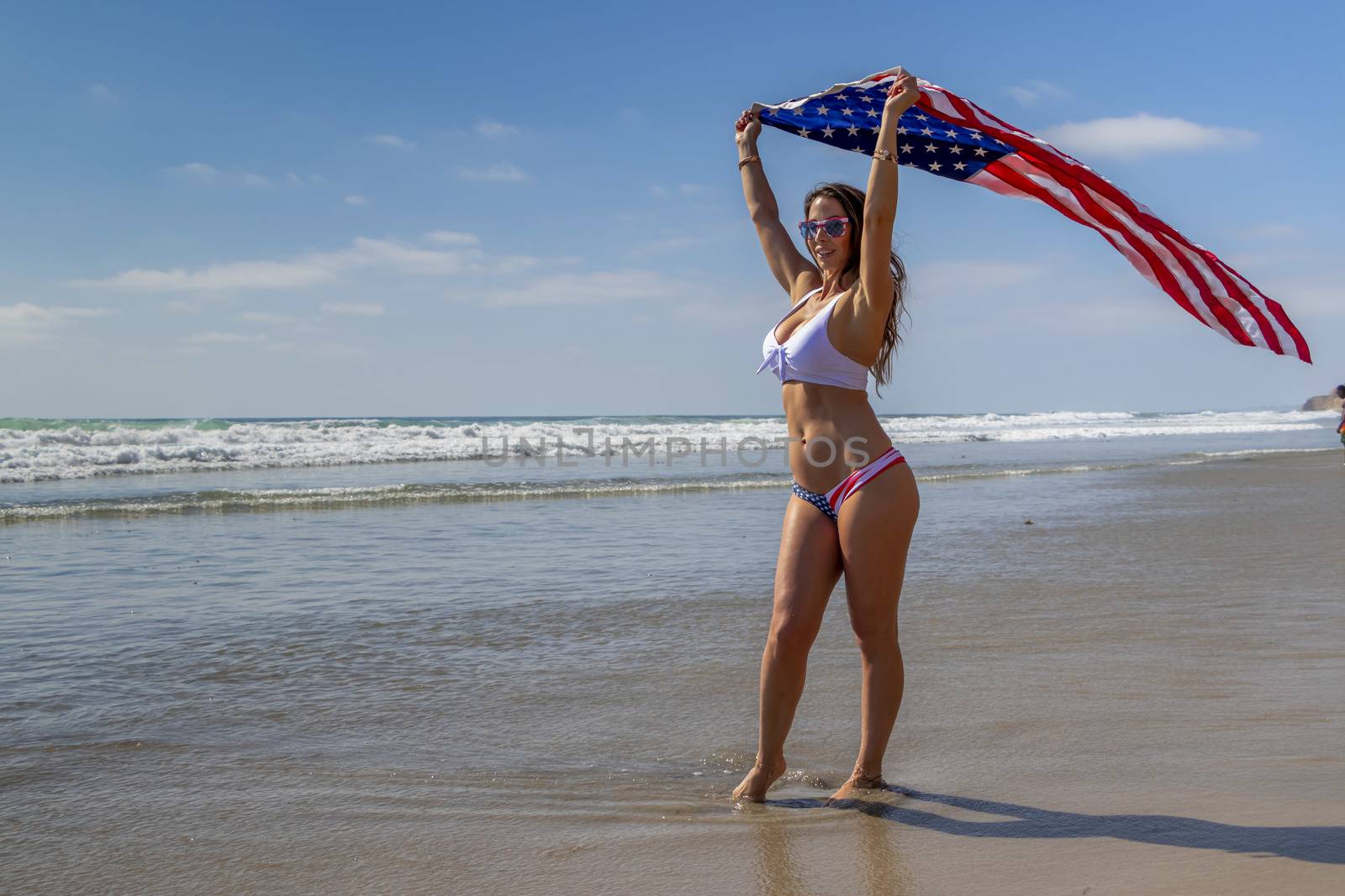 A Lovely Patriotic Brunette Model Poses On The Coast With An American Flag by actionsports