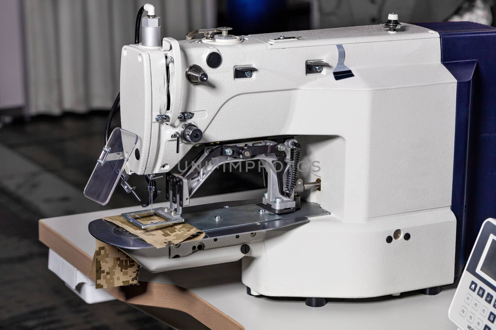 Professional sewing machine, equipment for hemming and sewing clothes, close-up. by Sergii