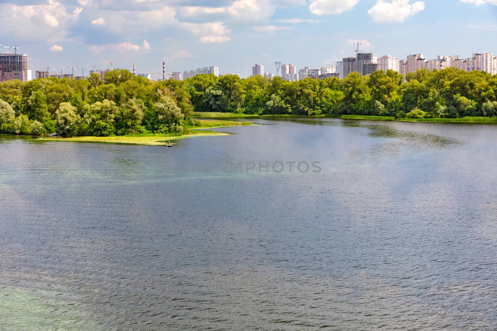 Natural picturesque landscape of the Dnipro bay. In the background, the city's residential area under construction is visible. by Sergii