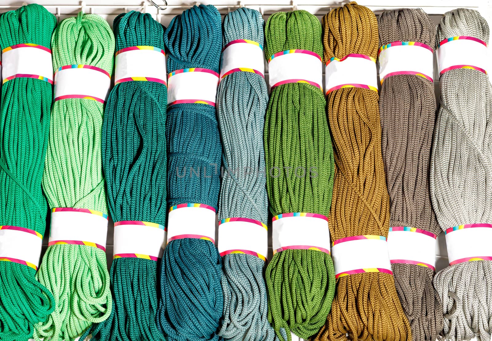 Skeins of polyester cord in various bright colors of green and beige. by Sergii