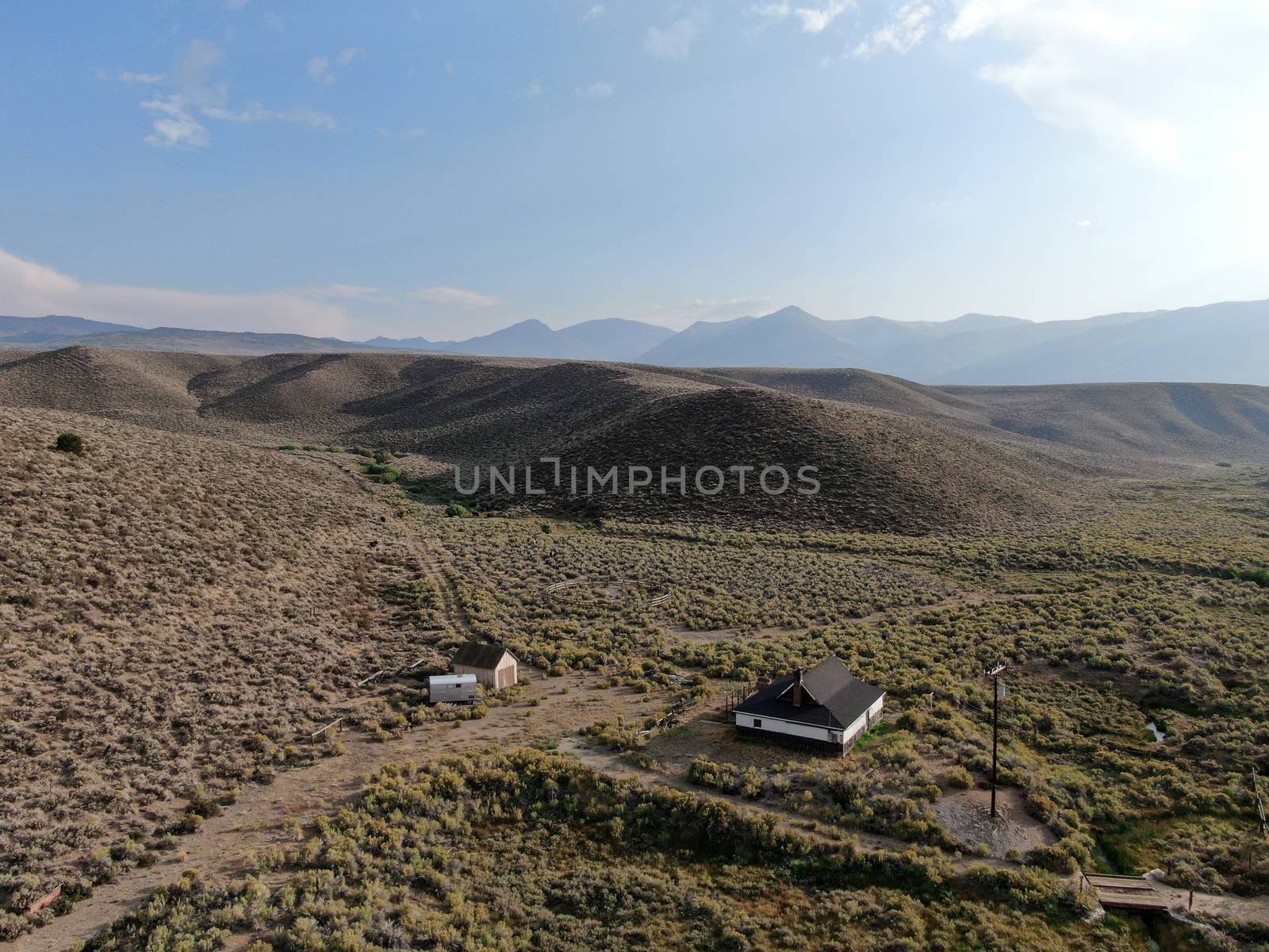 Old wood ranch in the middle of the desert valley by Bonandbon