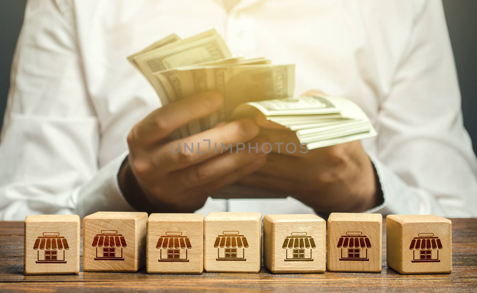 Blocks symbolizing business network and businessman counting money. High income from commercial real estate rent. Taxes payment. Building a successful business empire. Franchise concept. Investments