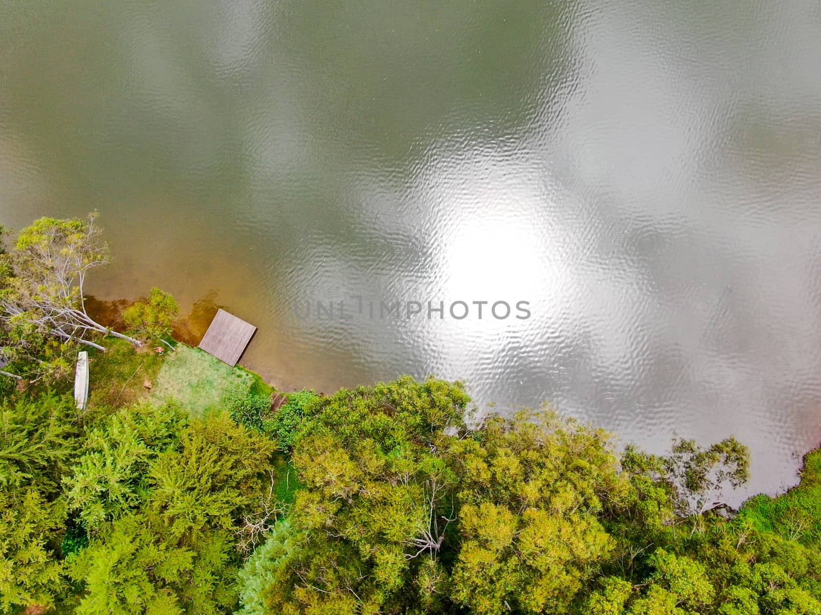 Aerial view top view of beautiful little wood pier next the lake in tropical forest mountain. Monte Alegre Do Sul, Brazil.