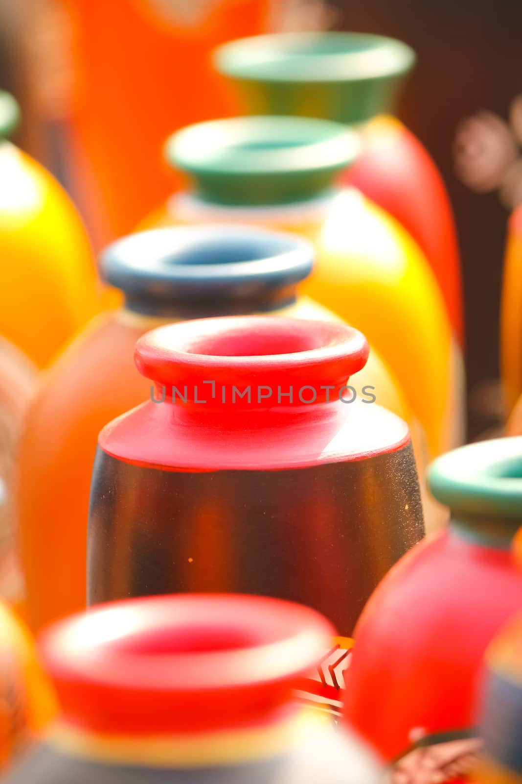 Closeup of red-brown colored earthen vase in a row; selective focus