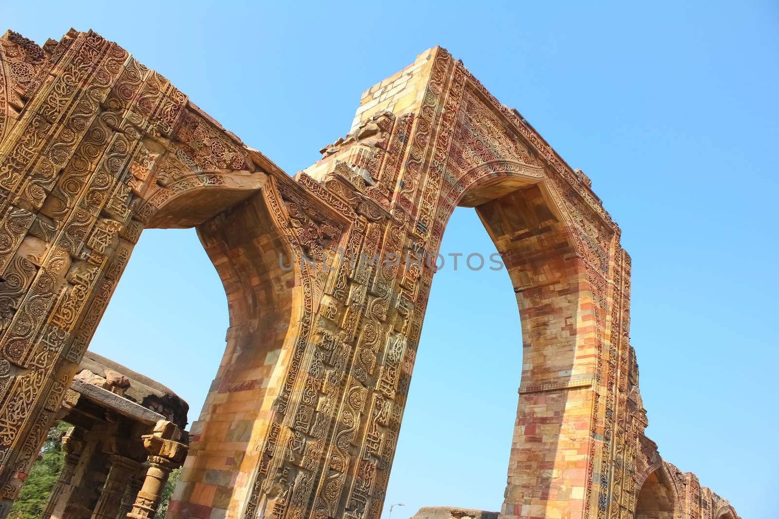 Intricate work of carvings and verses from holy Quran on the red and buff sandstone of Qutab Minar entrance arch