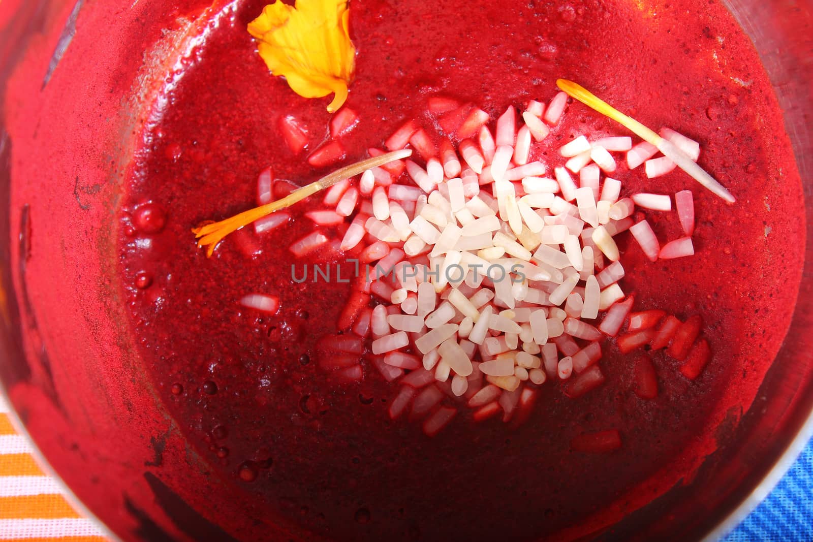 wet kumkum in bowl with rice and flowers