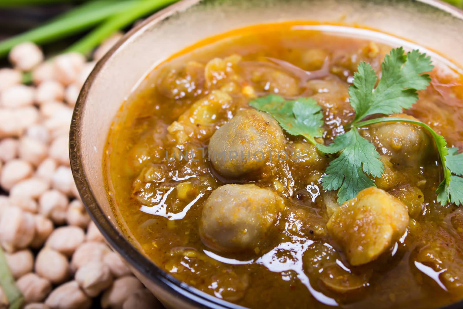 spicy chana masala, raw chickpeas around the bowl, indian dish