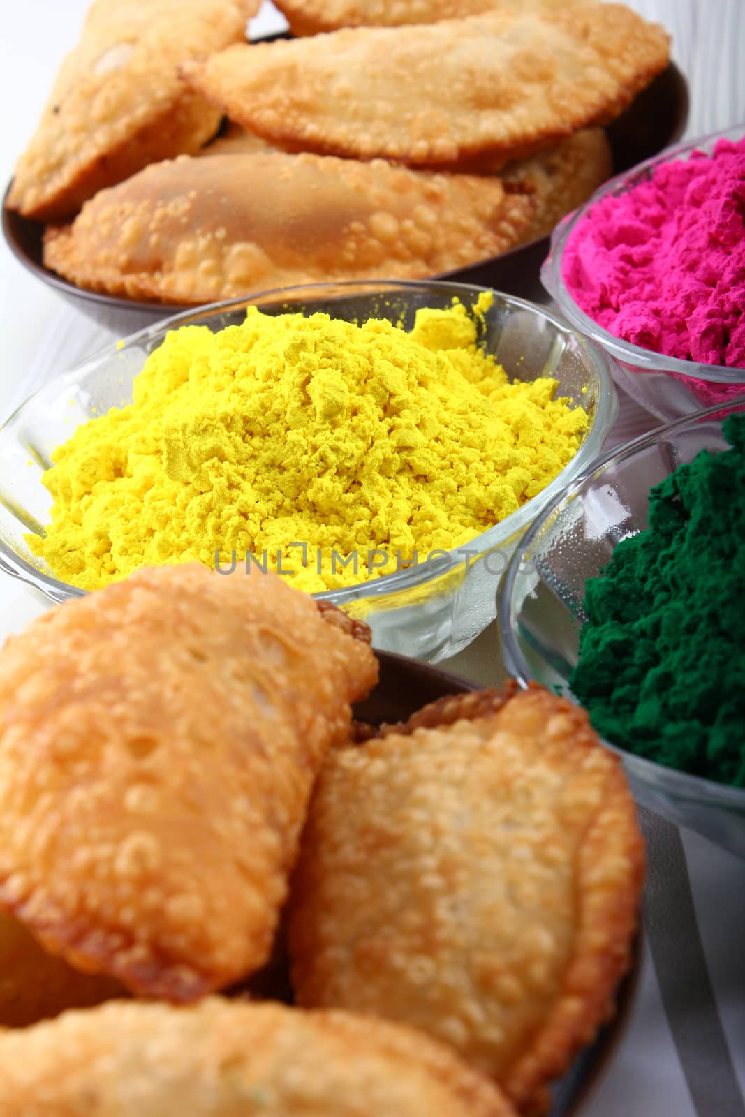 multiple holi colors with gujiya at background