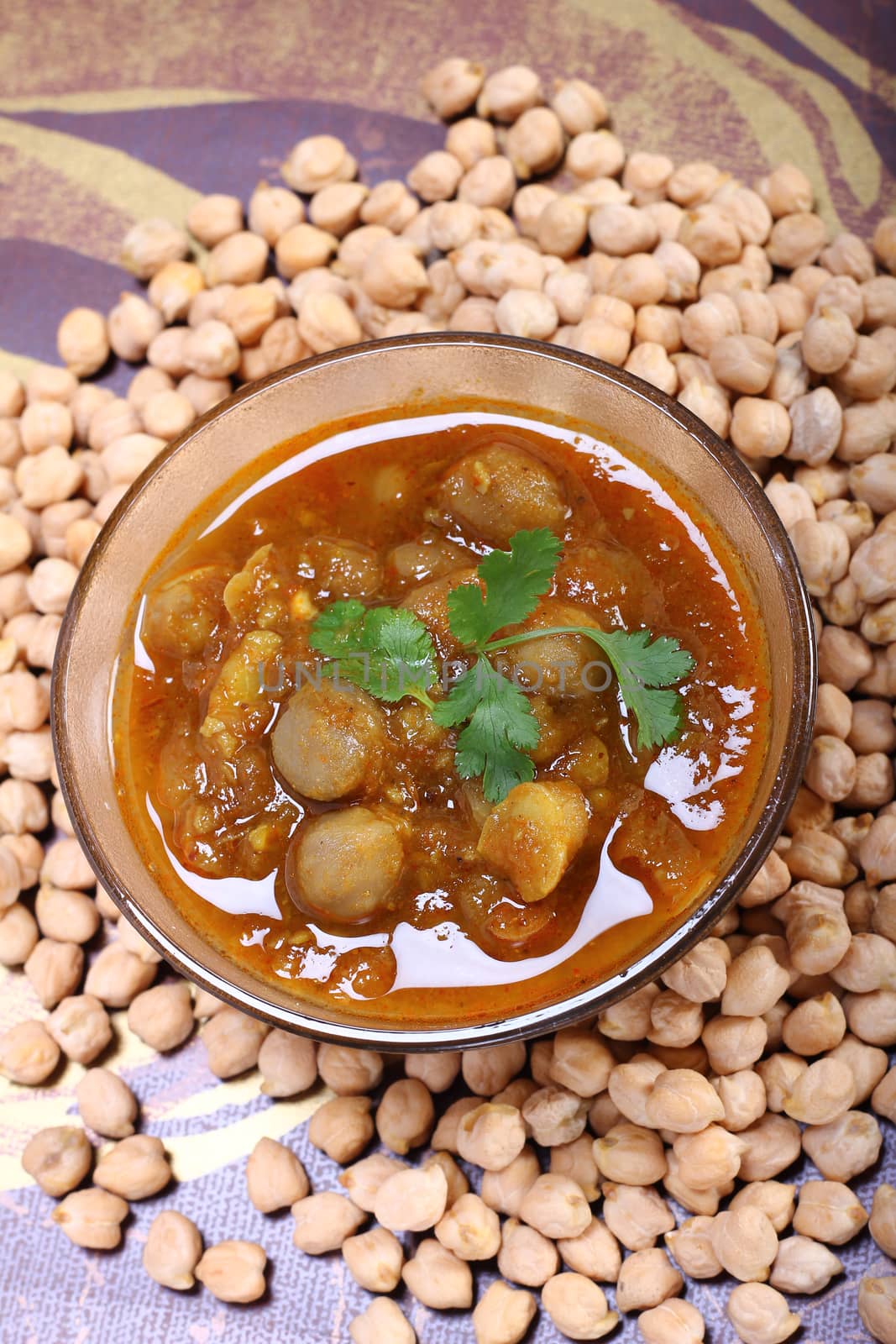 spicy chana masala, raw chickpeas around the bowl
indian dish