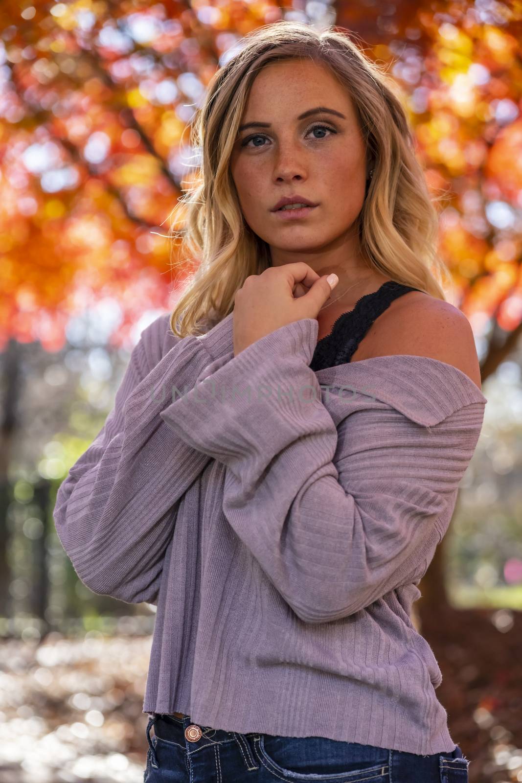 A gorgeous blonde model enjoys a Autumn day outdoors in a park