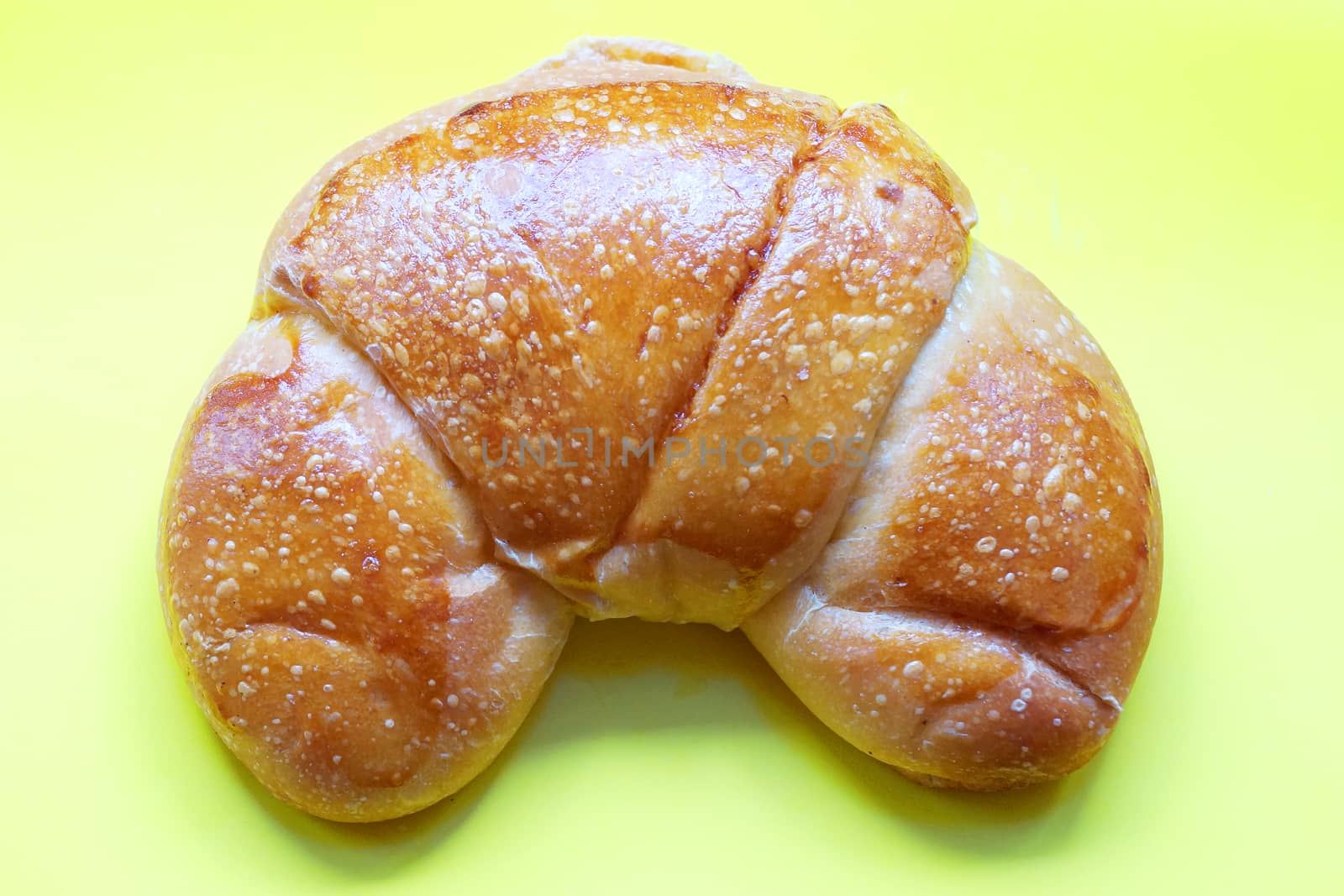 butter french croissant on yellow background close up by Annado