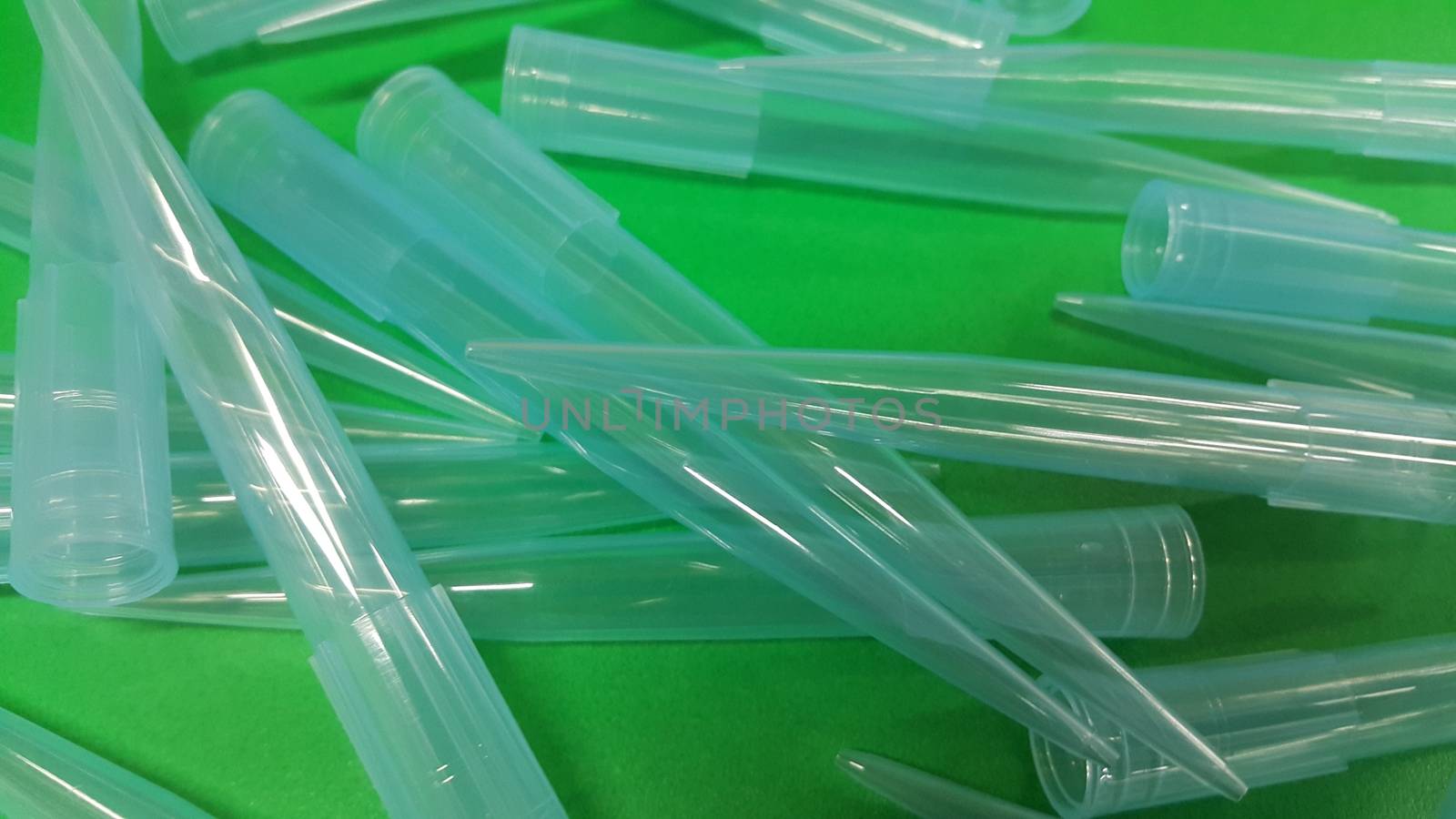 Close up view of micro litre tips on green floor sheet with empty holes. Reseach lab. tool for accurate measurement.