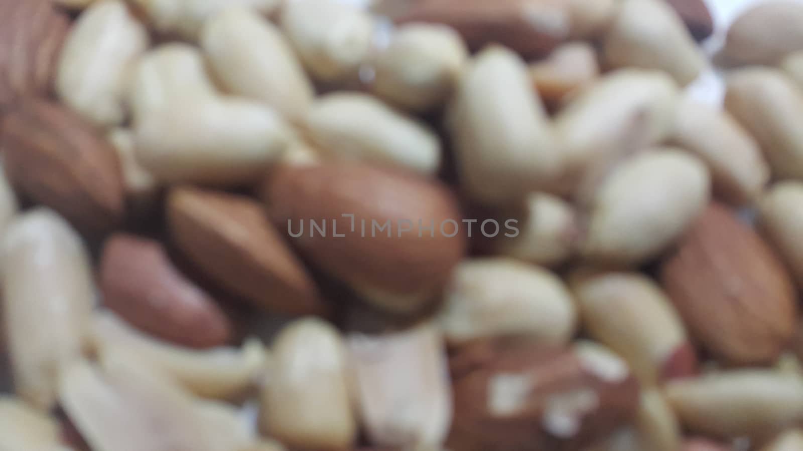 Closeup view of mixed dried and roasted  peanuts and almonds. A fruit for background text