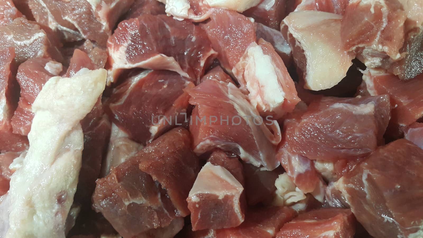 Close up view of fresh finely chopped meat cubes. Red meat small steaks with whitish meat fat.