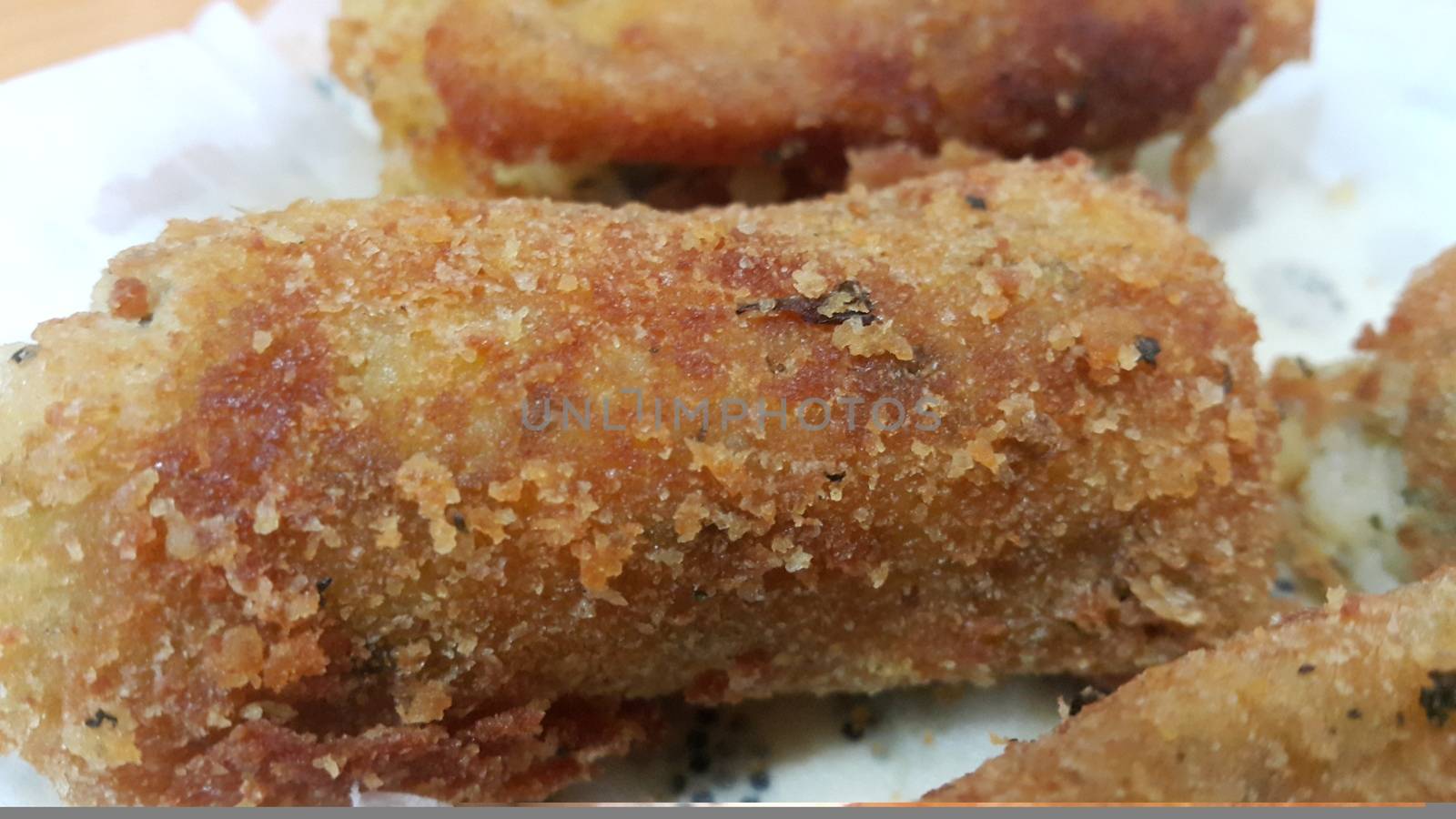 Closeup perspective view of home made spicy and delicious croquettes served in ceramic plate over wooden floor