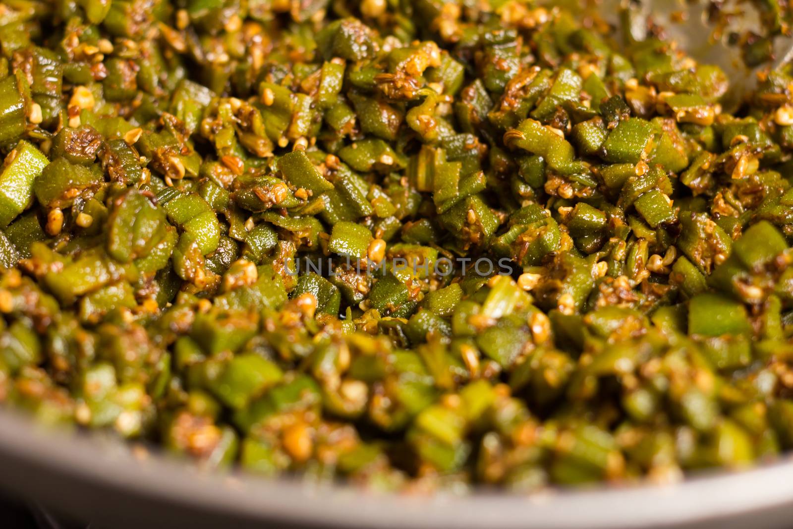 making home made masala bhindi or ladyfinger in karahi using spatula
