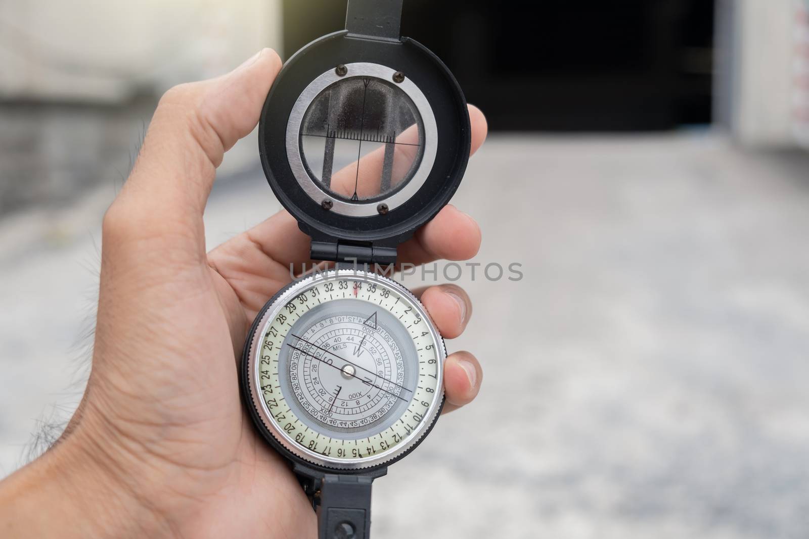man holding compass on blurred background. for activity lifestyl by oatzpenzstudio