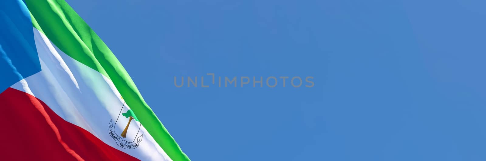 3D rendering of the national flag of Guinea waving in the wind against a blue sky