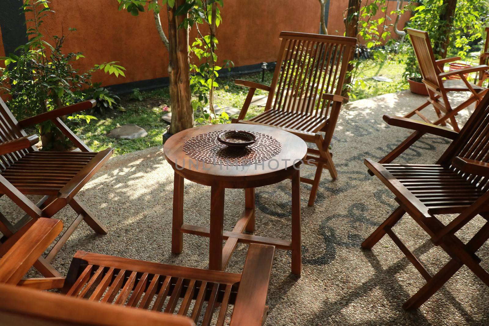 Set of wooden table and chairs in the garden. Teak wood furniture stand on the terrace.