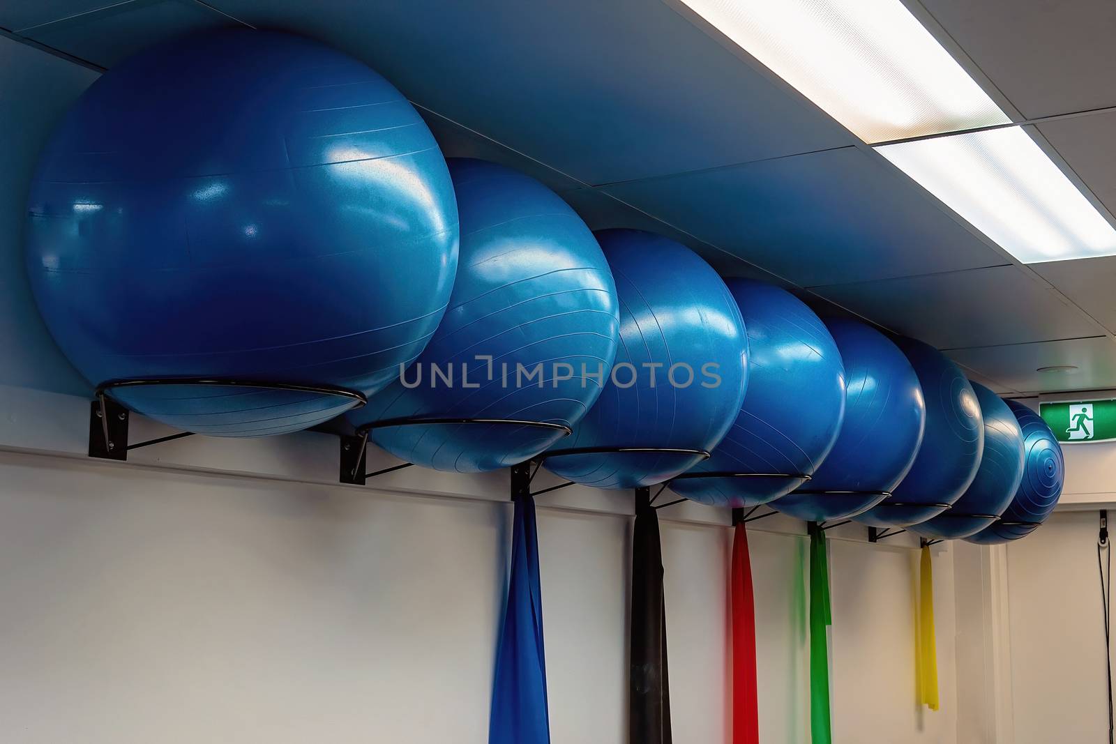 Large round blue pilates exercise balls in a row in a physiotherapist clinic