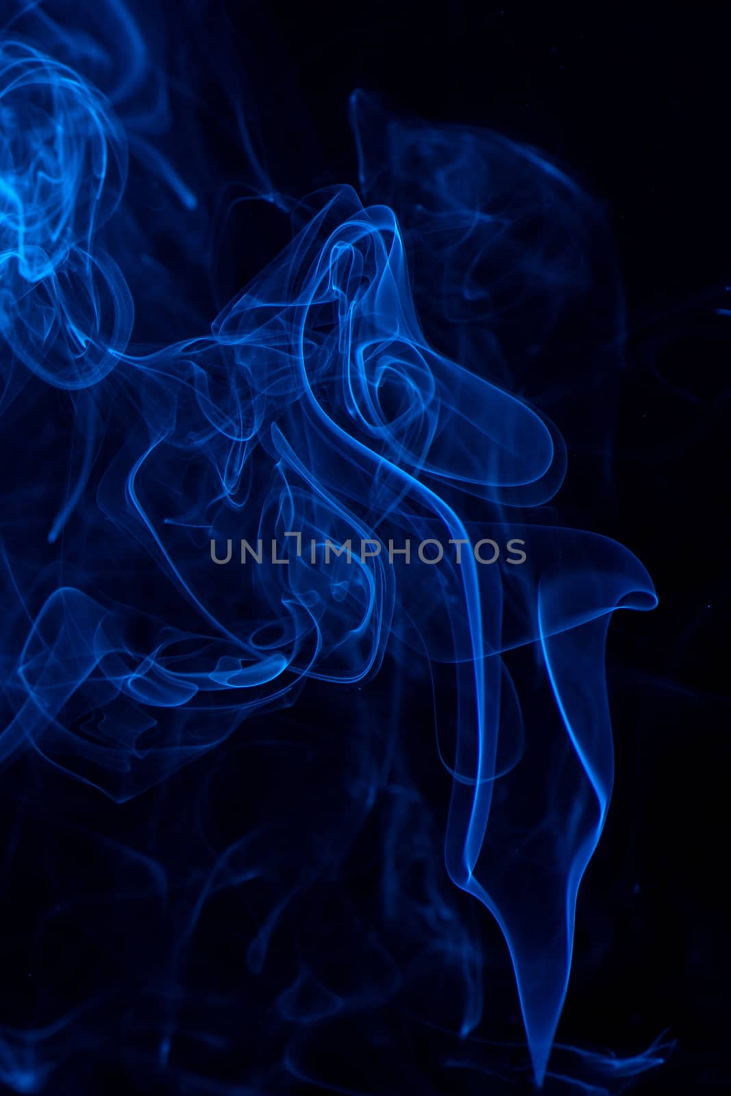 Conceptual image of blue color smoke isolated on dark black back by ROMIXIMAGE