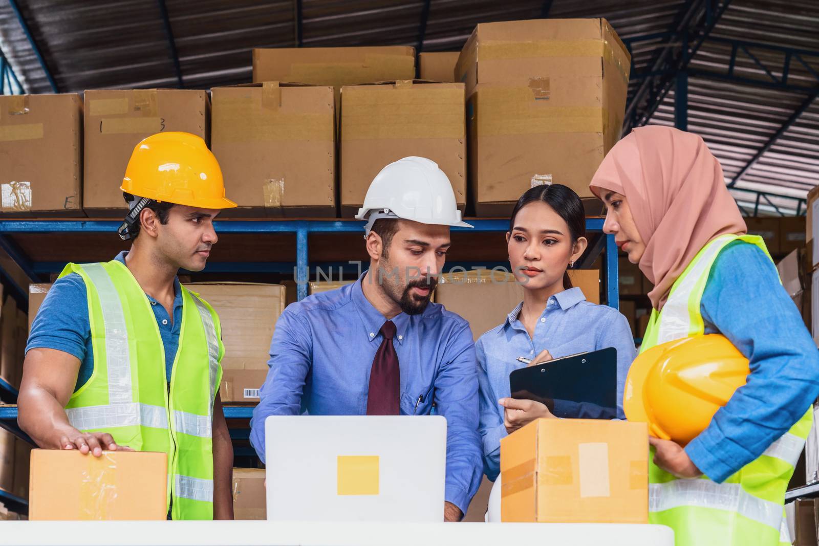 Group of Diversity warehouse worker meeting and brainstorming together in local warehouse, muslim with Hijab, indian, white caucasian and asian people wearing safety clothes in export industry concept