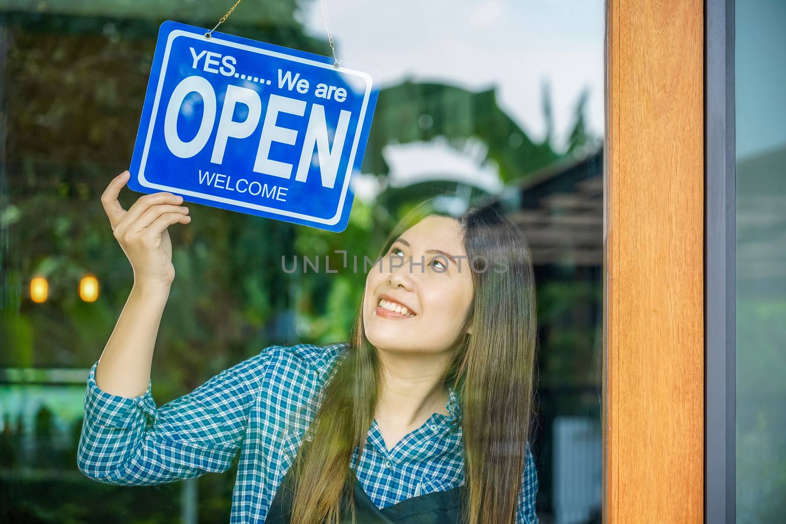 Asian young woman setting open sign at the shop glasses for welc by Tzido