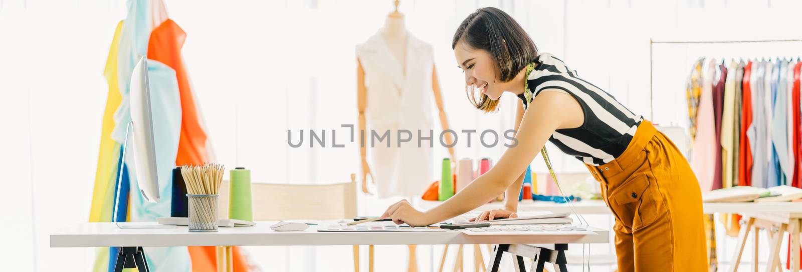 Young Asian designer woman working with computer and choosing multicolor chart at workplace, small business startup, Business owner entrepreneur, modern freelance job lifestyle concept. asia people