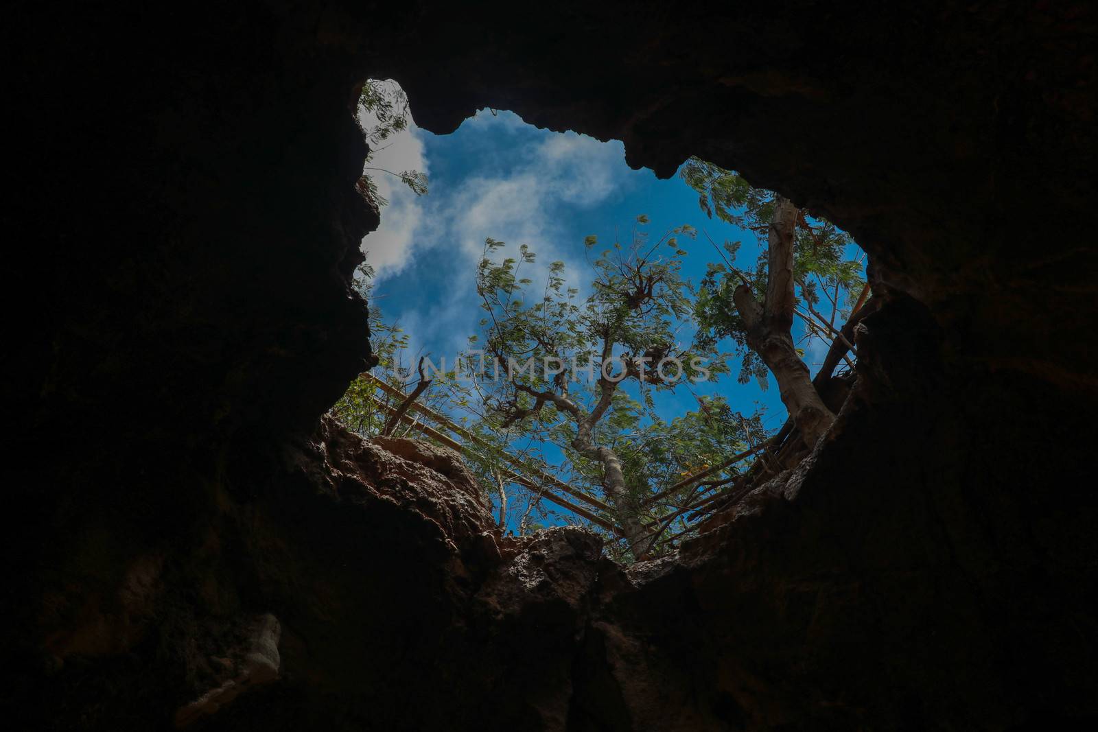 View from inside a cave looking out.Fallen cave ceiling. A hole in the ceiling of the cave.
