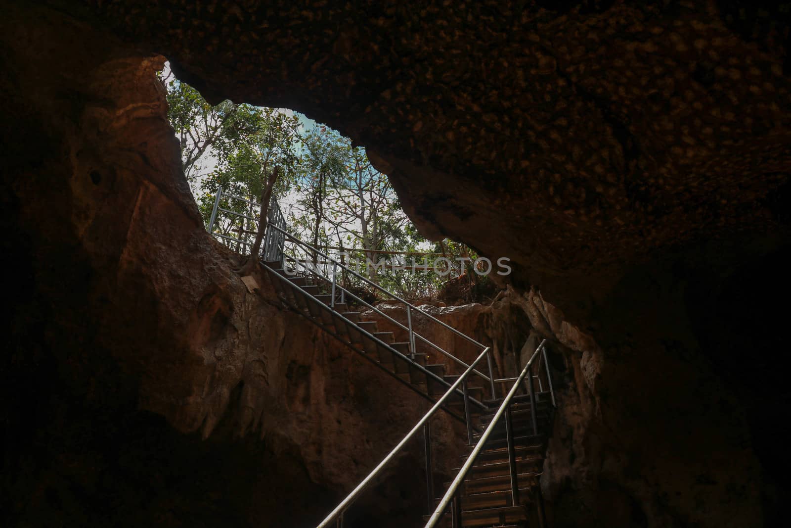 Stainless steel staircase in the cave. Stainless steel staircase to GOA BANGKANG PRABU cave, a bat cave on Lombok island, Indonesia. Bottom view of the blue sky.