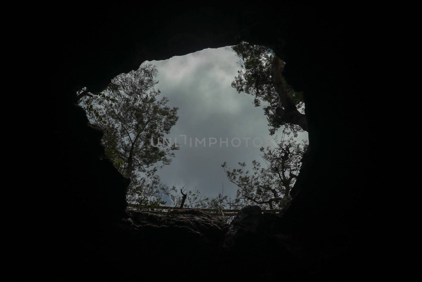 View from inside a cave looking out.Fallen cave ceiling. A hole in the ceiling of the cave.
