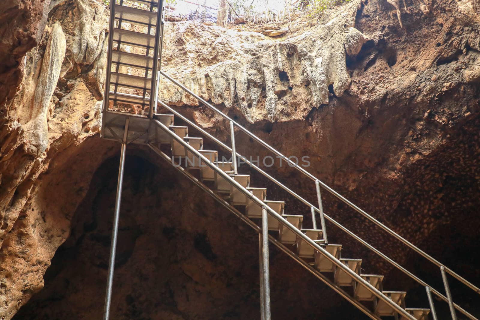 Stainless steel staircase in the cave. Stainless steel staircase to GOA BANGKANG PRABU cave, a bat cave on Lombok island, Indonesia. Bottom view of the blue sky.