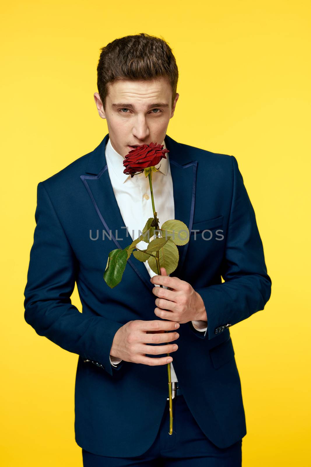 Lovers men woman with red rose in hands romance holidays yellow background family friends. High quality photo