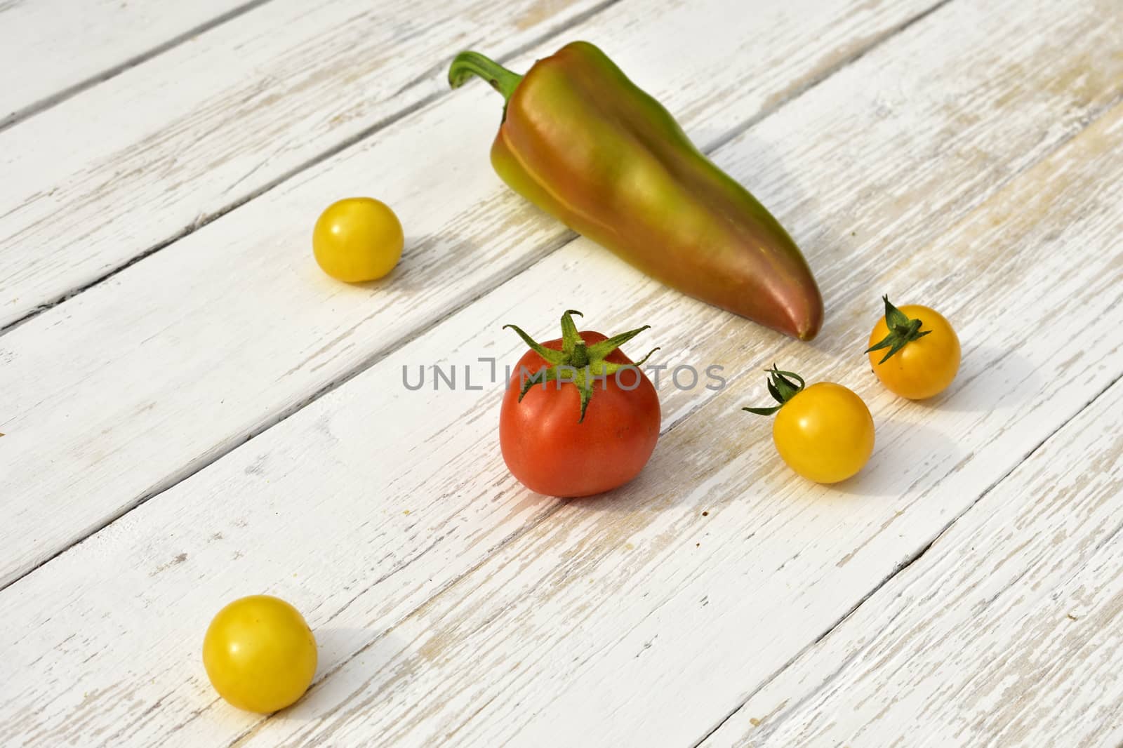 red tomato four yellow tomatoes bell pepper pod on a wooden vintage table