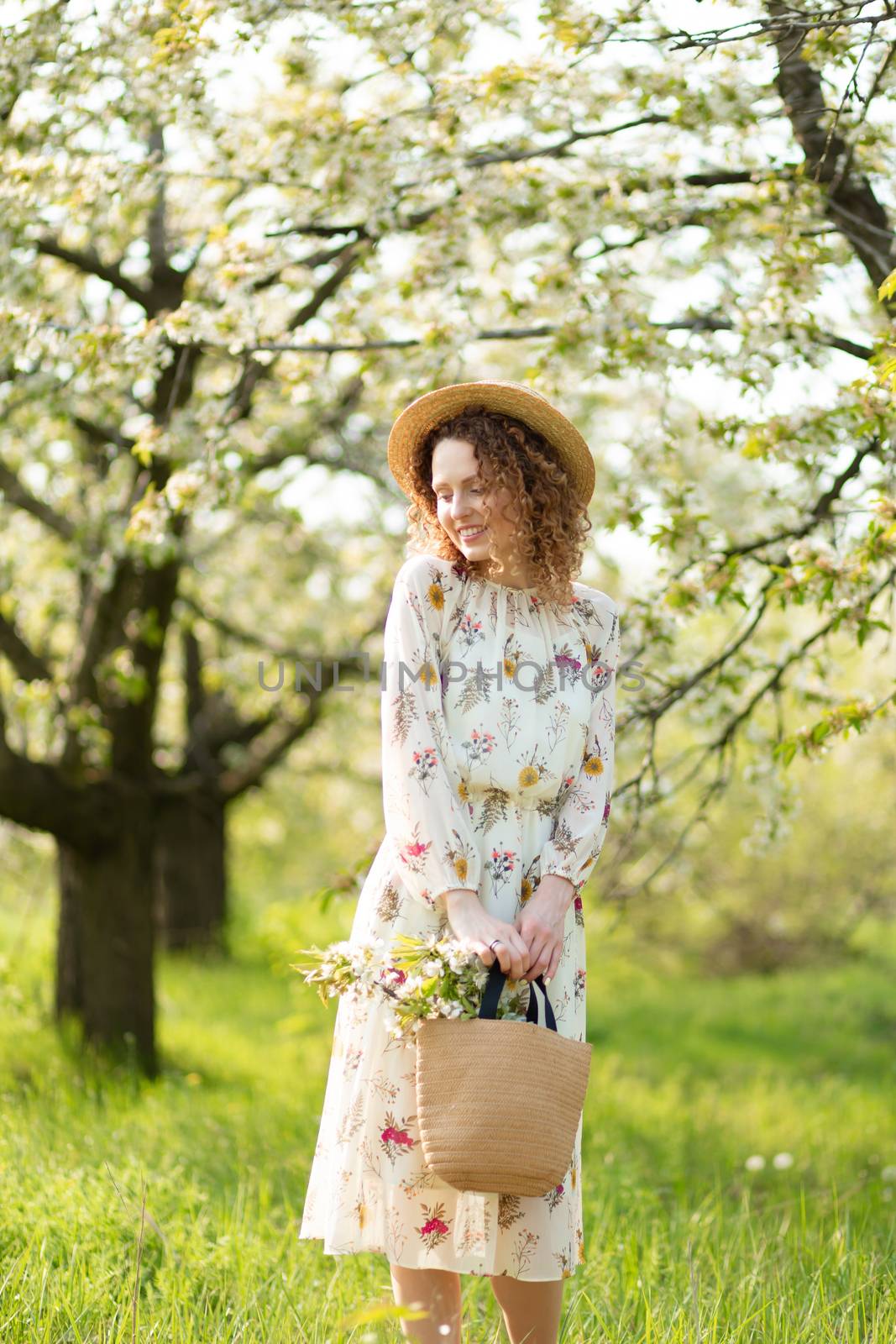 A gorgeous girl walks in a flowering spring garden. The concept of unity of man with nature.