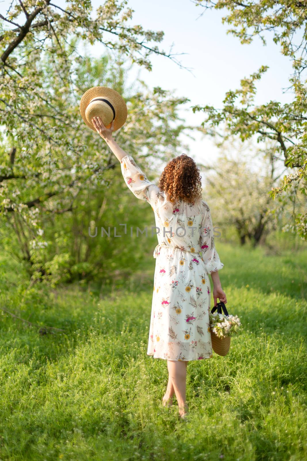 A gorgeous girl walks in a flowering spring garden. The concept of unity of man with nature.