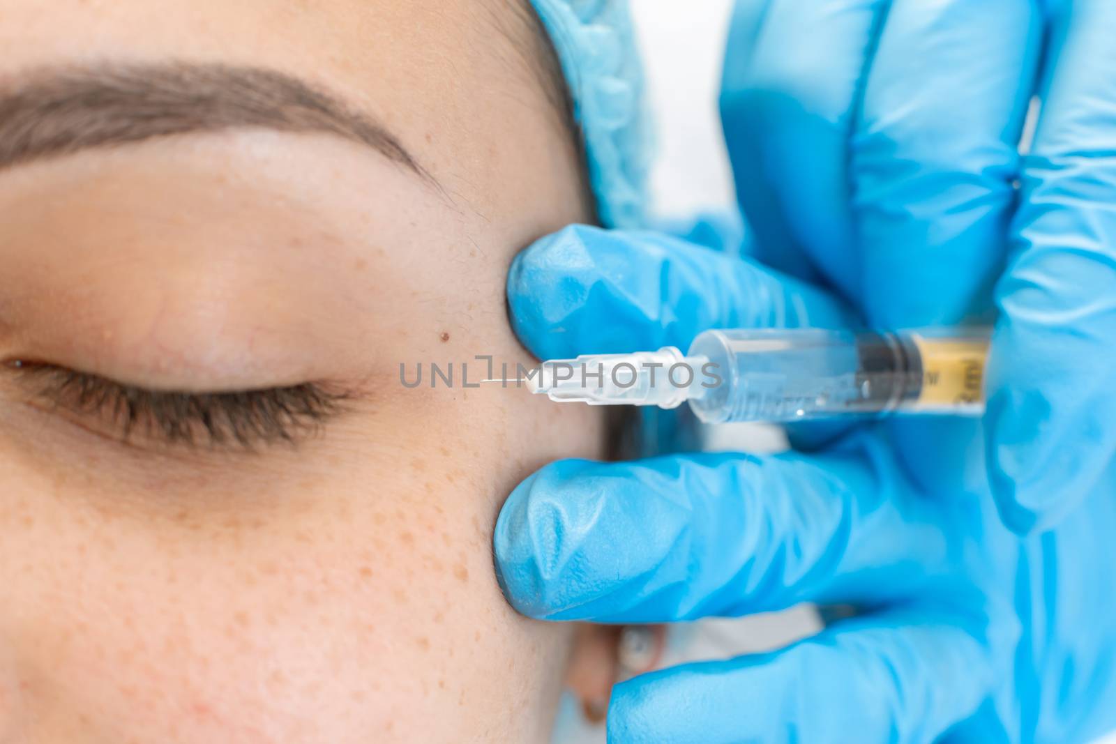 Close-up, beautician makes beauty injections into the skin of a young beautiful girl. Facial care and rejuvenation