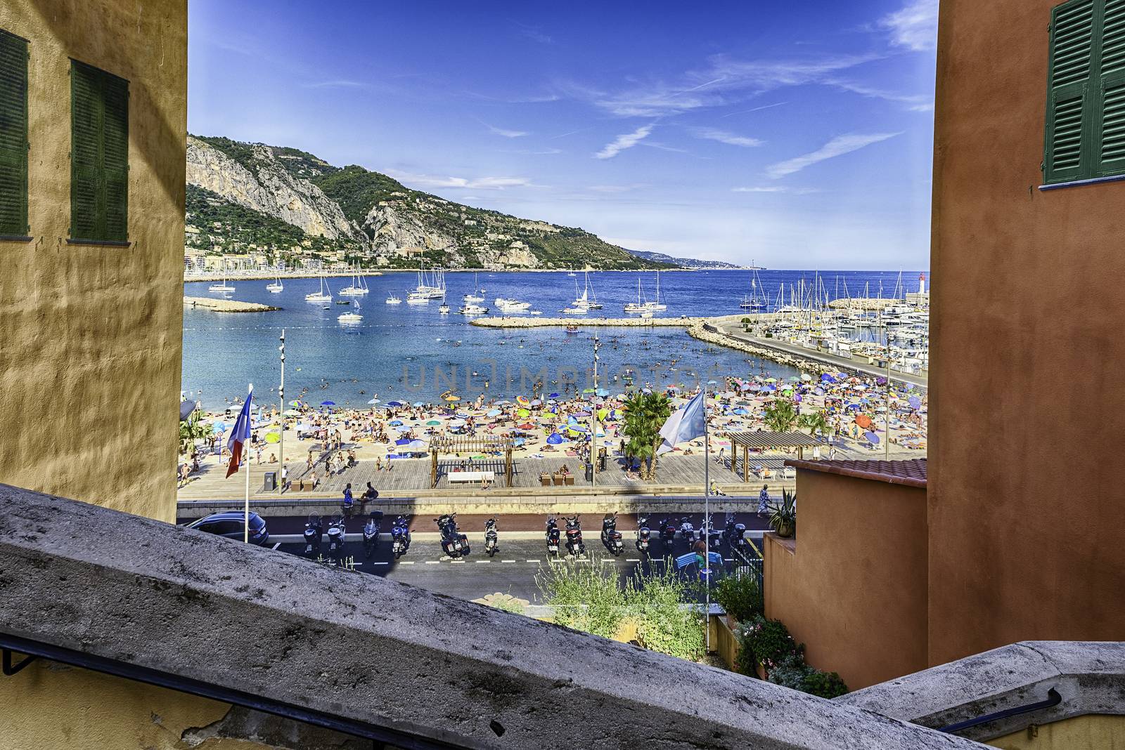 Scenic view over the beach in the city centre of Menton, Cote d'Azur, France, with the Italian coastline in the background
