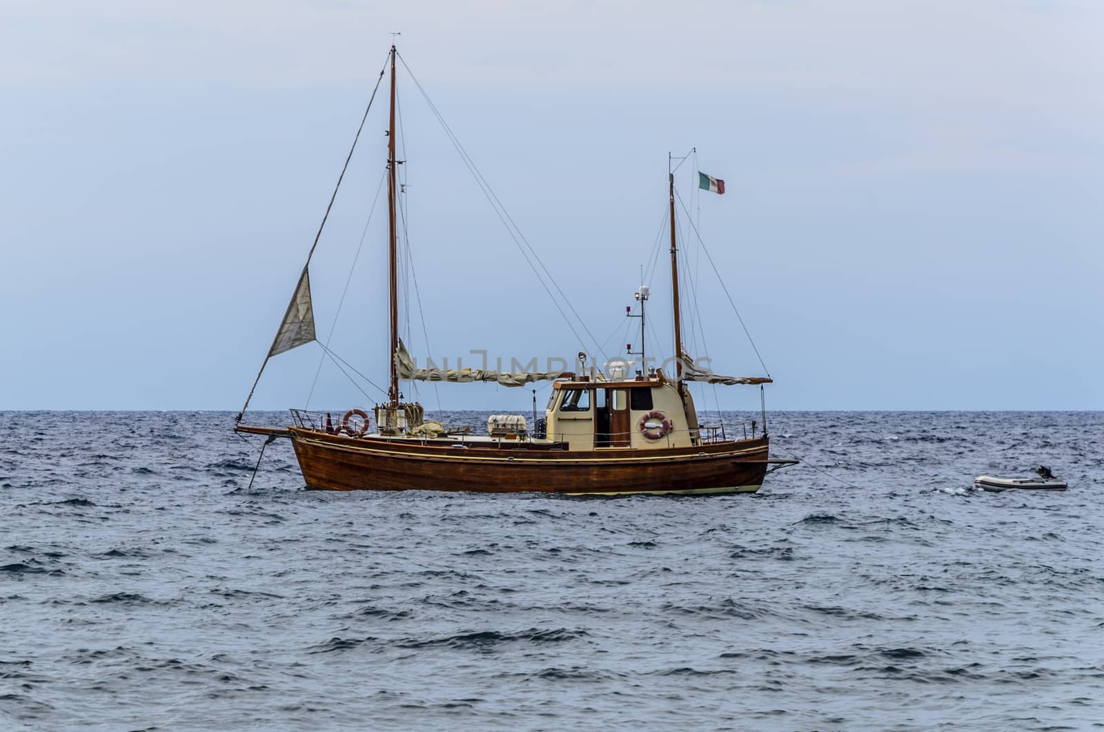 Sailboat and its lifeboat in waters of the Tyrrhenian sea off the island of lipari italy