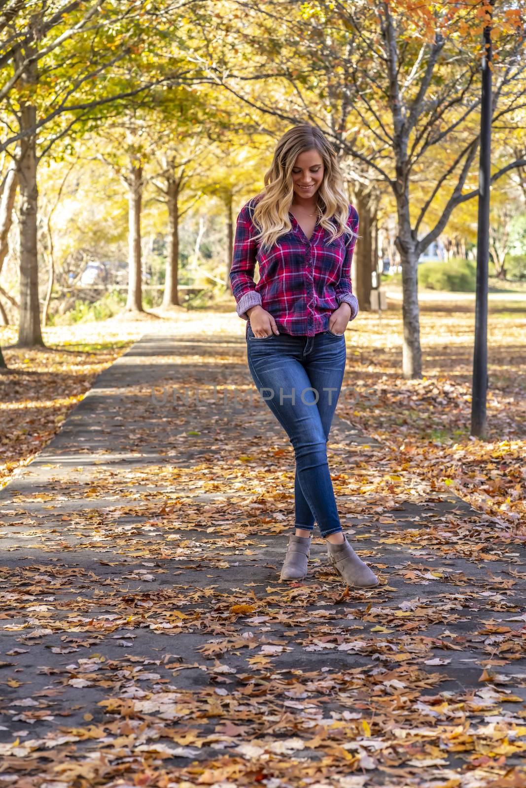 A gorgeous blonde model enjoys a Autumn day outdoors in a park