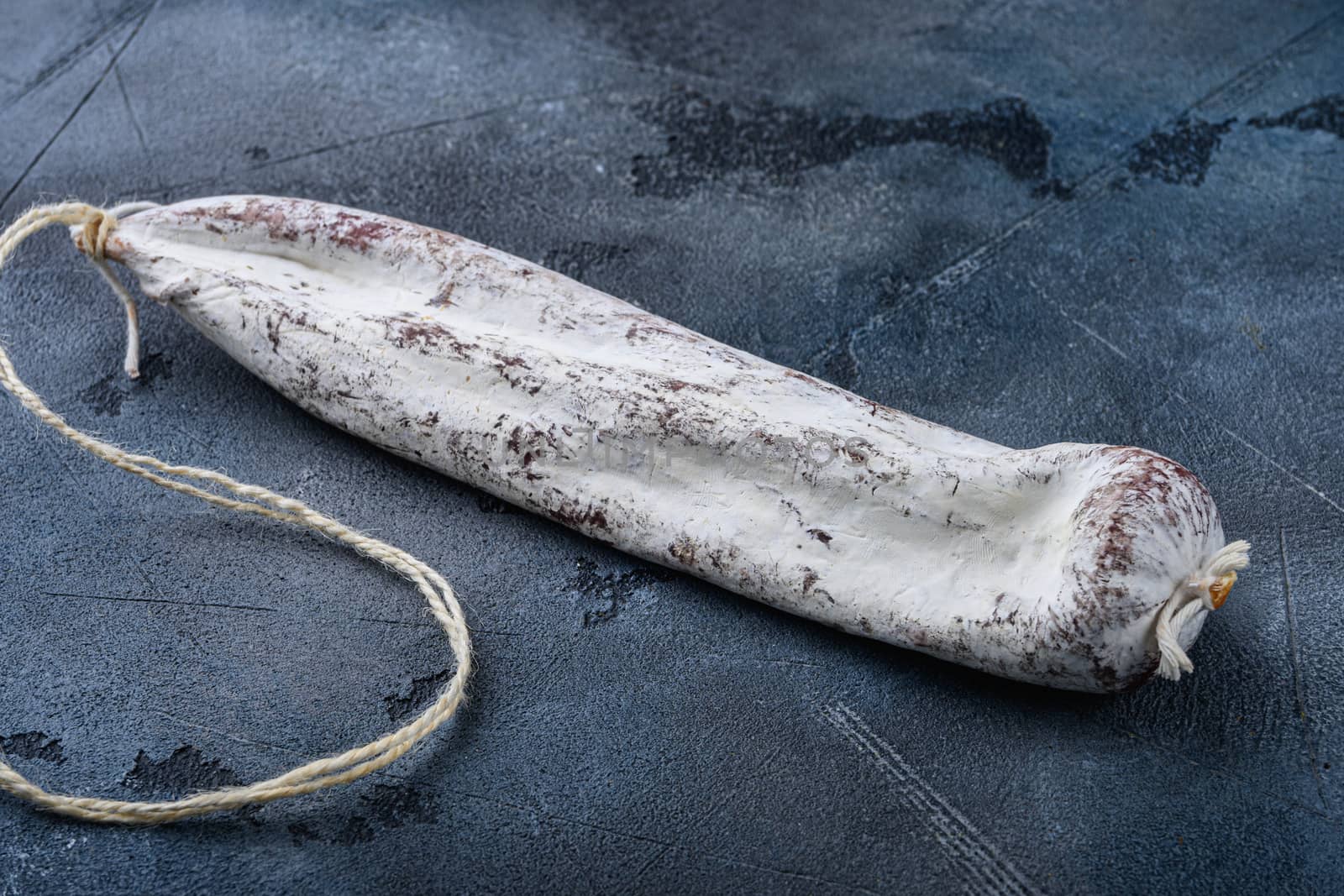 Whole spanish longaniza wurst on blue background.