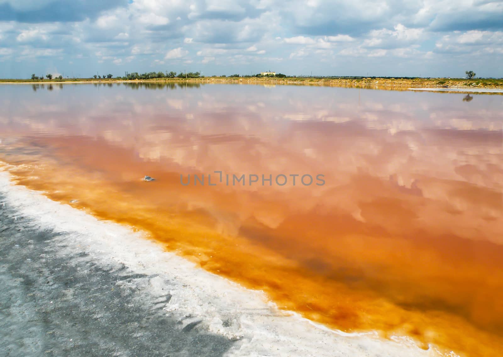 The salty shore of the lake of salt. The water looks red-orange due to a special algae that grows in high levels of salt.
