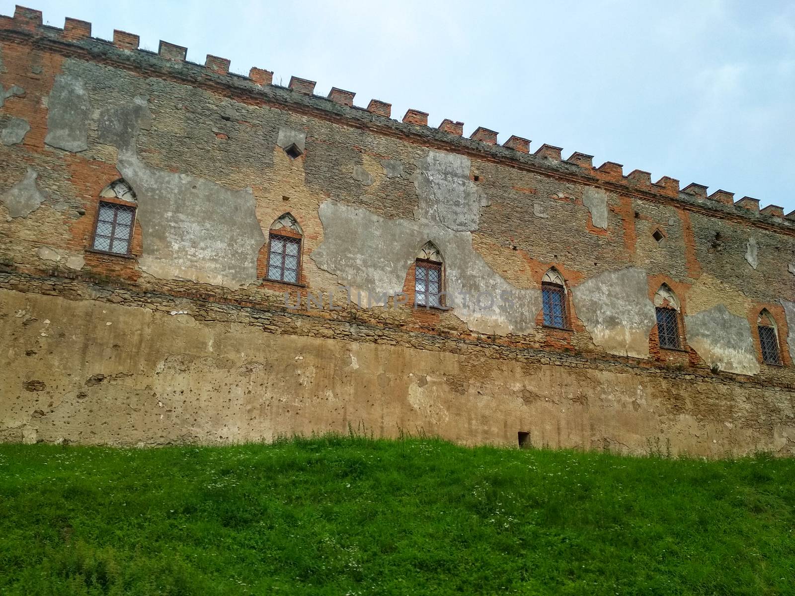 defensive wall of the old castle with windows and loopholes by mtx
