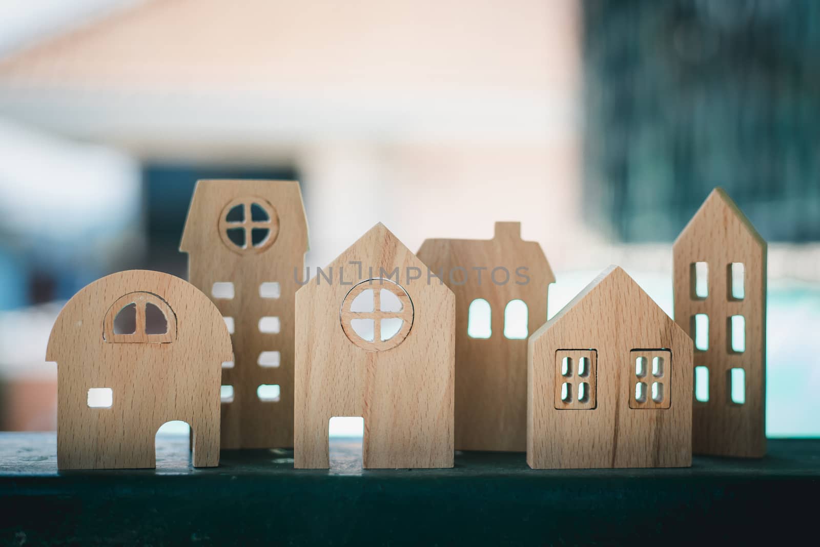 Wooden house model against blurred outdoor background for housing and property concept
