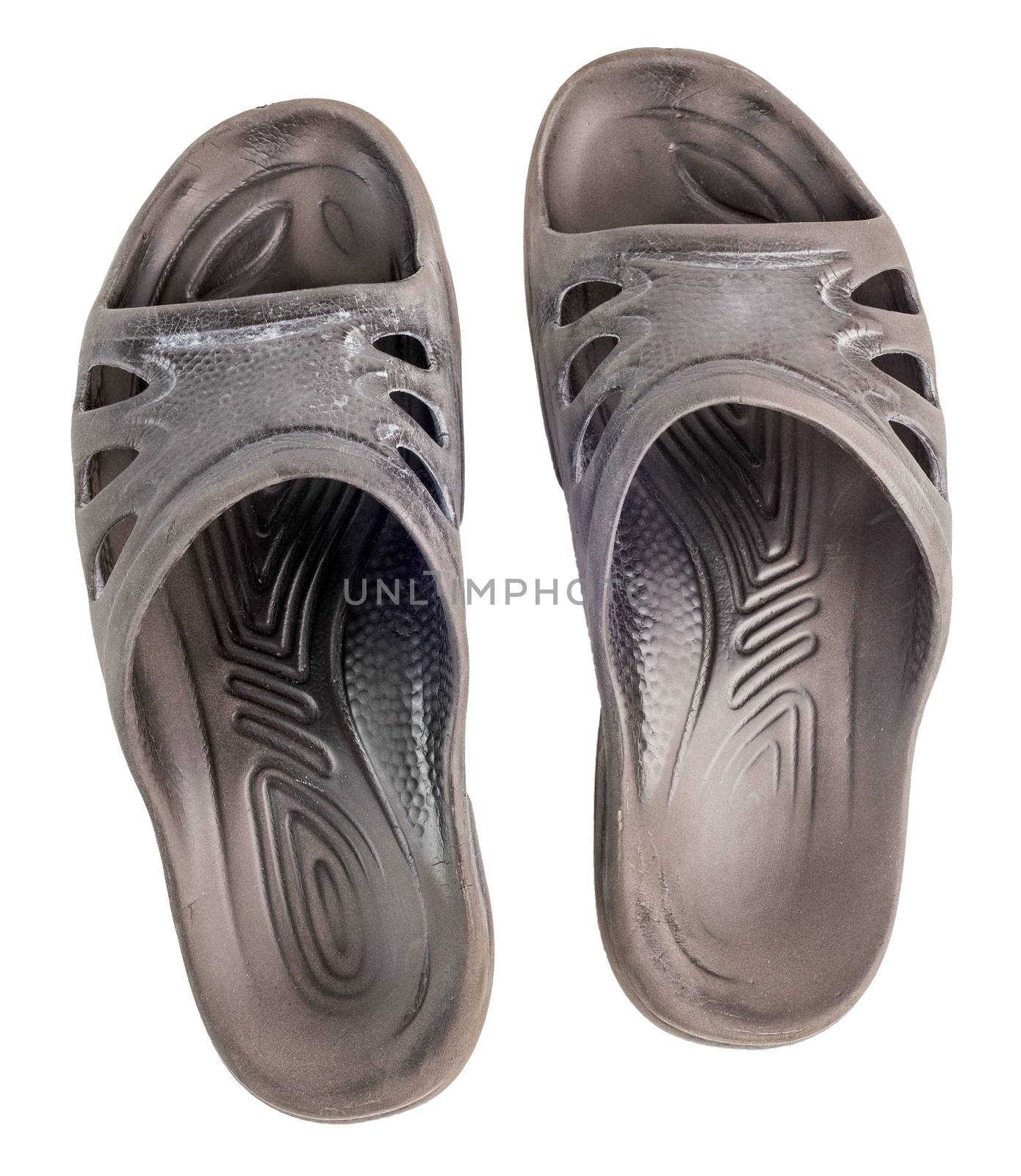 A pair of old black rubber slippers isolated on white background, view from above.