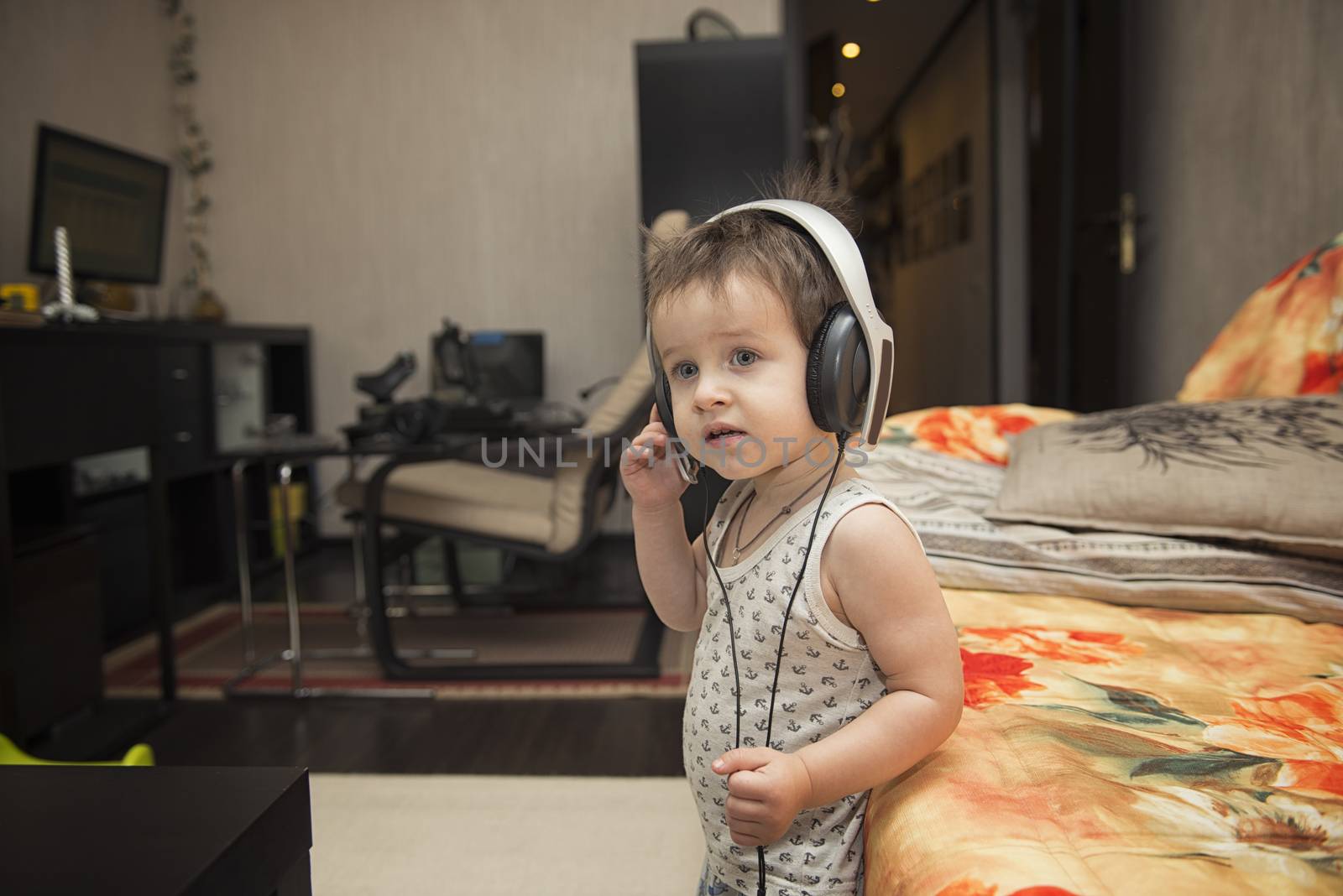 Charming boy listening to music in headphones by marynkin