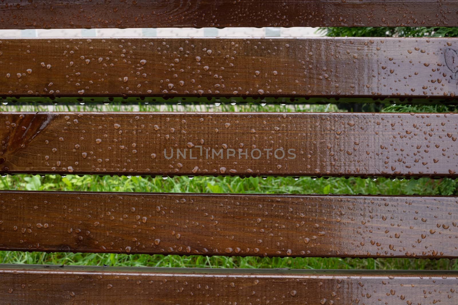 Drops of water on wooden bench after the rain, natural weather background.